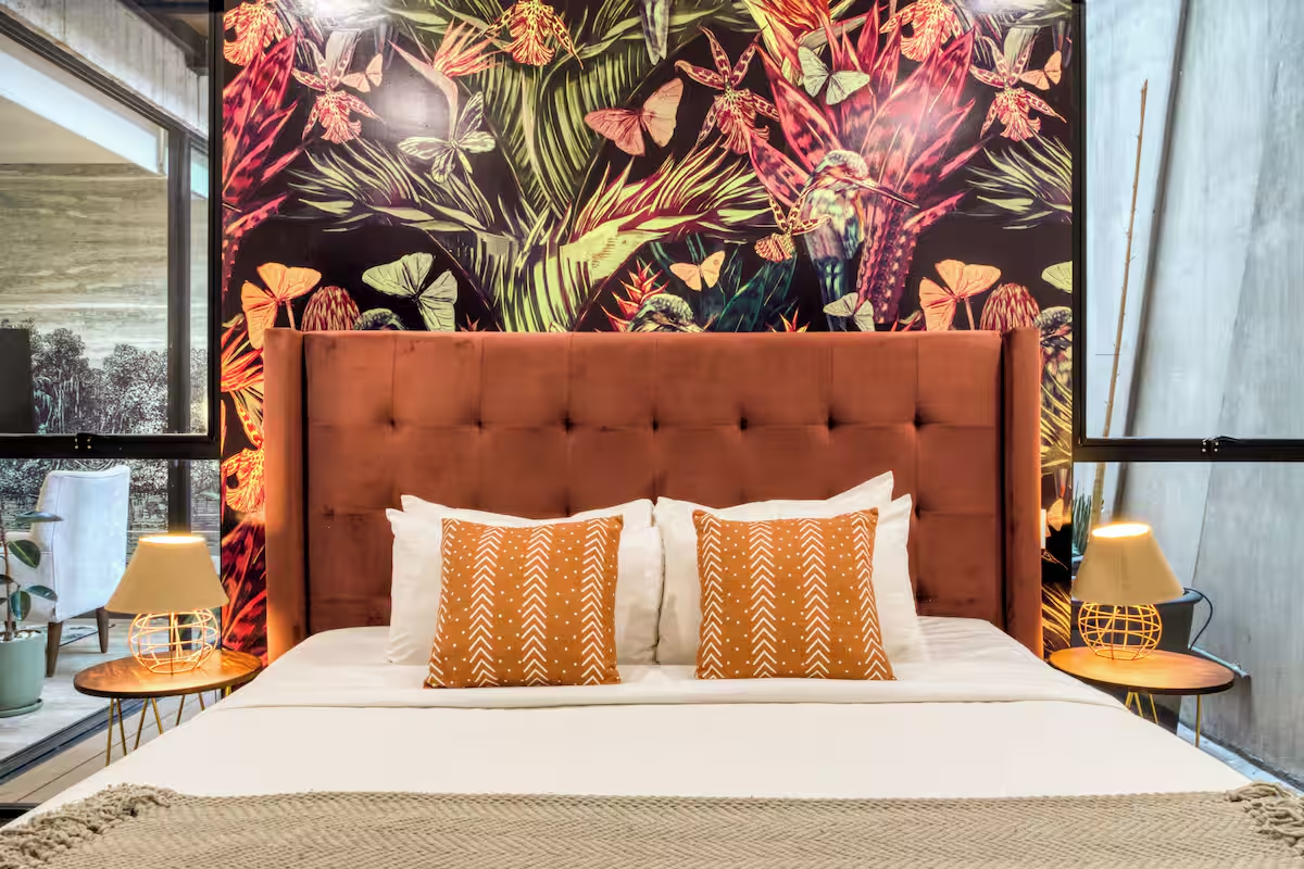 Departamento Junior — recámara con cabecera de terciopelo y papel tapiz tropical en MEDELLIN by Mr W